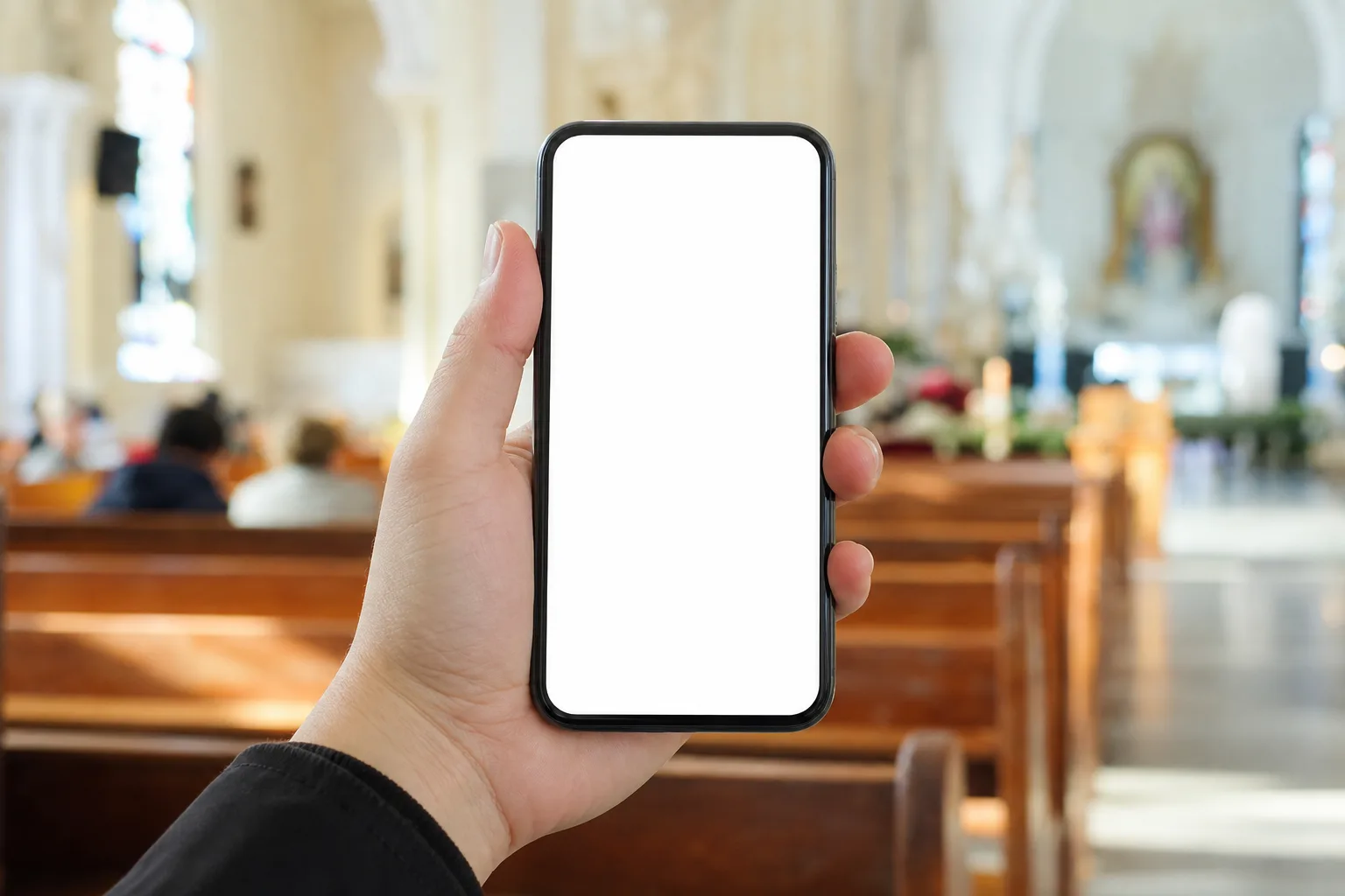 A hand holding a phone to read captions in a church